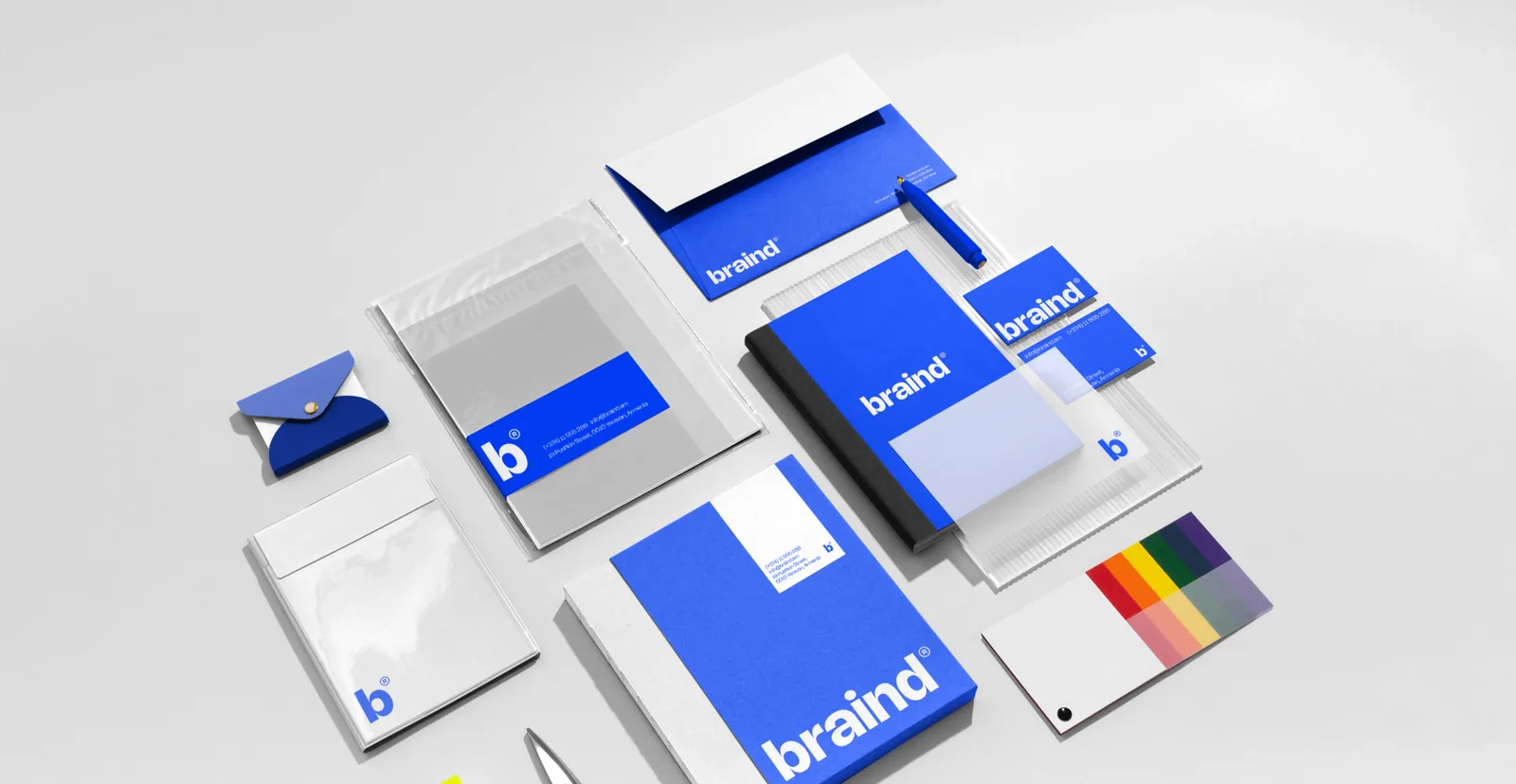 Braind stationery laid out: letterhead, envelopes, folder, notebook, business cards and a pen, in Braind Blue and white